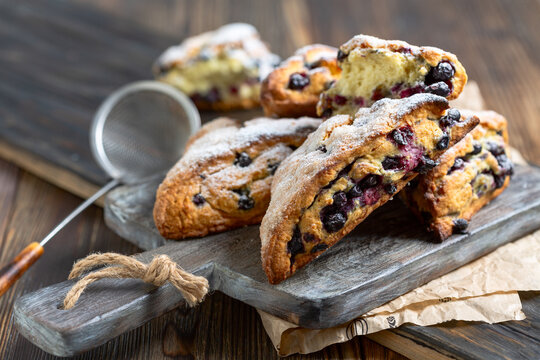 Homemade skones with berries on wooden board. Healthy vegan dessert concept.