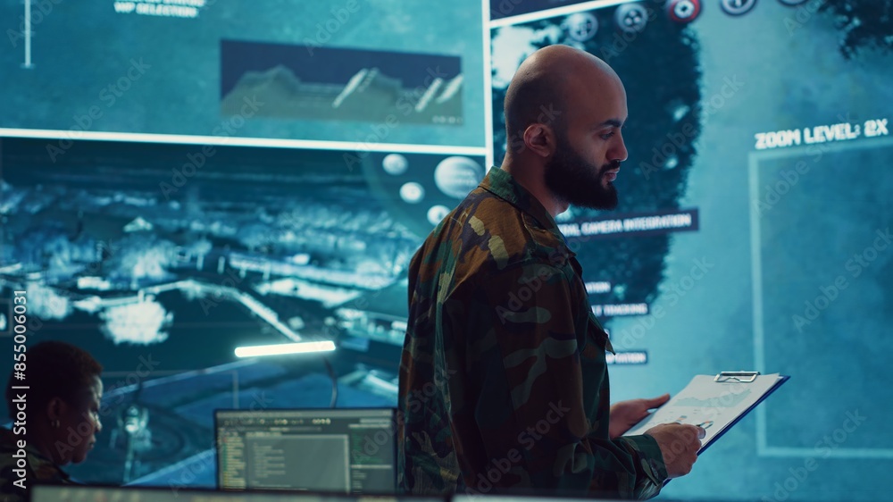 Poster army officer examining real time satellite data on big screen in military power base, gather intelli