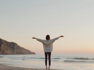 Obraz premium Embracing Serenity: Person Standing on Beach at Sunset with Arms Outstretched in Joyful Gesture of Contentment