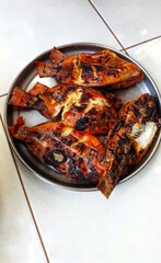 cooking grilled fish on a fire made of wood charcoal 