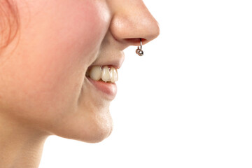 Closeup of a young smiling woman's visage with piercing septum hanging from her nose. Side voew.