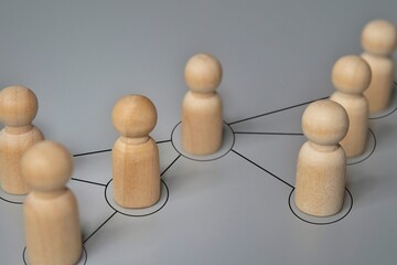 Obraz premium Wooden dolls connected by lines. Cooperation and interaction, disseminating information, rumors concept.