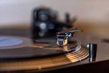 Close up of turntable stylus (needle) on black vinyl record