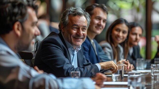 A group of business executives and corporate leaders gathered around a boardroom table discussing strategy and planning for their company s future  They are engaged in a high level discussion