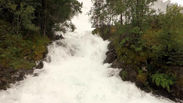Floods in Norway, water stream near Langfoss waterfall, static shot
