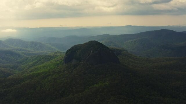 Aerial orbiting Looking Glass Rock Brevard NC in golden morning light