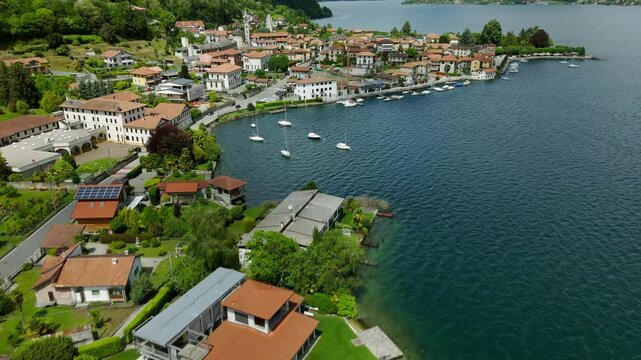 Aerial flyover of picturesque Italian village on shore of Lake Orta, Italy