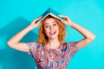 Portrait of nice lady hold opened book head wear t-shirt isolated on teal color background