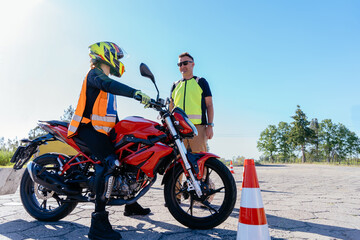 Driving instructor showing motorcycle commands and dashboard to the inexperienced student. Learning to ride motorcycle.