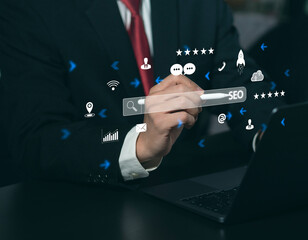 Businessman presses on laptop keyboard to use search engine (SEO) to find customers or promote and advertise online content for marketing technology and business solutions.