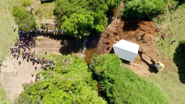 Aerial Bird&rsquo;s-Eye View of an Excavator Positioning a House Near River Crossing in Chilo&eacute;, Chile.