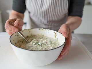 Woman in the kitchen with a fresh prepared homemade tartar sauce or remoulade