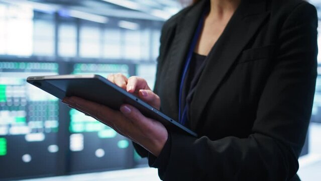 Computer scientist managing data center with advanced technology using digital device. Close up shot of person in server room optimizing data center gear with tablet, camera B