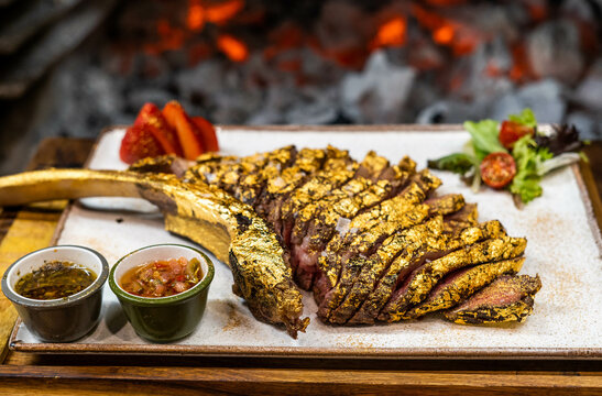 Premium beef tomahawk coated in edible gold - Powered by Adobe