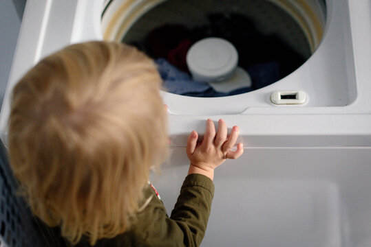 Child looking into a top-loading washing machine