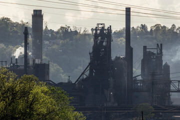 A steel mill smokes and steams in natural environment © Cavan