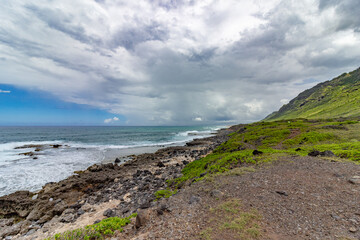 Dramatic coastal landscape with rocky shore and mountains in Hawaii.