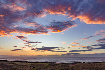 Fototapeta premium Dramatic sunset with vibrant clouds over the ocean in Hawaii.