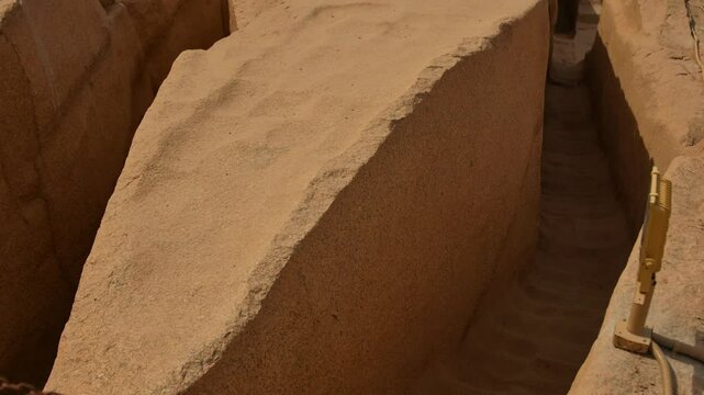 Revealing shot of unfinished obelisk mega monument of Ancient Egypt at stone quarries of ancient Egypt in Aswan