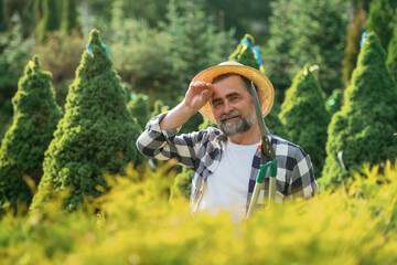 Tired, taking a break. Senior gardener is at work at daytime