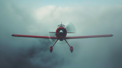 A red airplane is flying through a cloudy sky