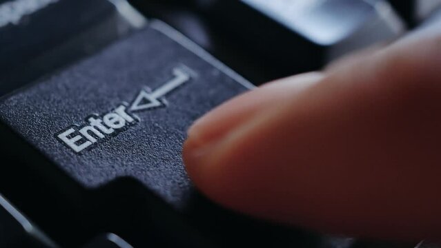 Close-up of finger press a key on the keyboard Enter, Macro shot of finger pressing Enter button on keyboard, Keyboard button Enter
