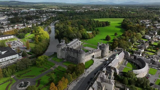 Kilkenny Castle, County Kilkenny, Ireland, September 2023. Drone locked in a station position as clouds and shadows roll across River Nore and green landscape.