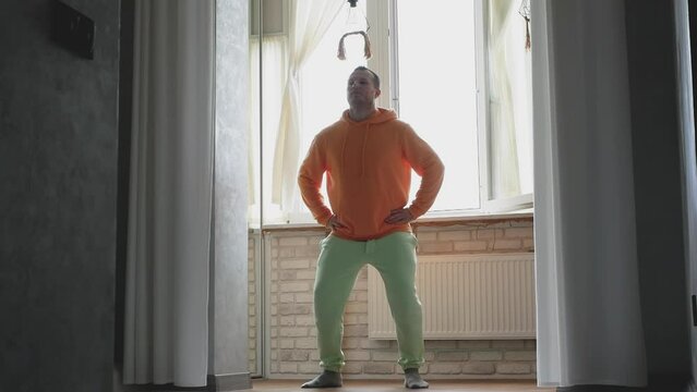A dancer is warming up, a male gymnast is in training. Handsome sportsman at dance lessons