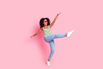 Full length photo of crazy girl wear top in sunglass dancing on one leg look at offer empty space isolated on pink color background