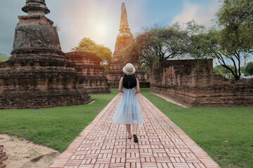 Historical local travel Thai concept, Happy traveler asian woman with dress sightseeing in Wat Phra Si Sanphet temple with pagoda background, Ayutthaya historical park, Ayutthaya, Thailand

