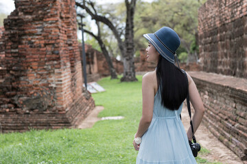 Historical local travel Thai concept, Happy traveler asian woman with dress sightseeing in Wat Phra Si Sanphet temple with pagoda background, Ayutthaya historical park, Ayutthaya, Thailand
