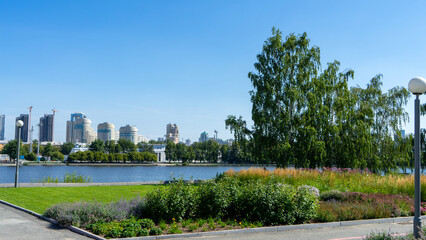 High-rise buildings on shore of city pond, Iset River, Yekaterinburg, Russia. View from square near Drama Theater