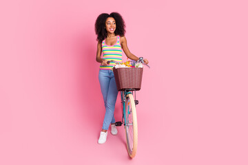 Full length photo of charming attractive lady wear striped singlet driving bike looking empty space...