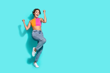 Full length photo of lucky excited lady dressed colorful top rising fists screaming yes empty space...