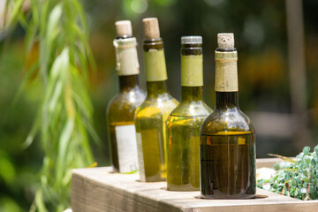 Four bottles of wine are lined up on a wooden shelf