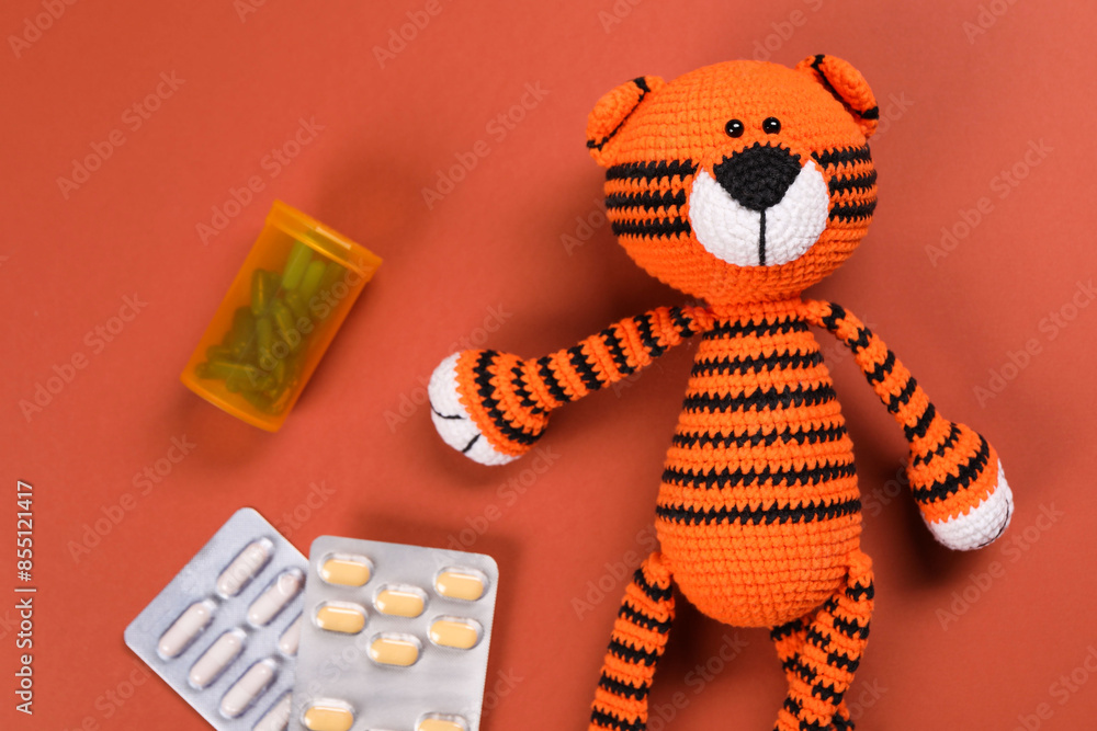 Canvas Prints Toy tiger and pills on orange background, flat lay