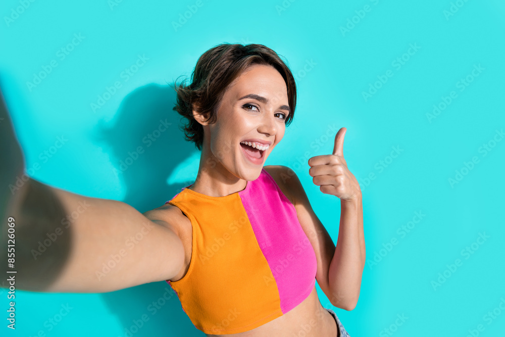 Sticker Photo of positive excited lady dressed colorful top showing thumb up tacking selfie isolated turquoise color background