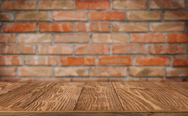 Wooden table against old brick wall as a background for displaying product