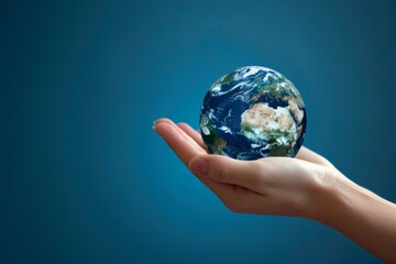 Hand holding planet earth on the palm of a hand. earth day concept, studio green background