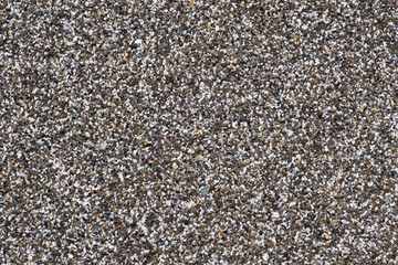 Gray coarse sea sand on the seashore. Sea sand closeup flat lay. Sea coarse sand top view flat layout.