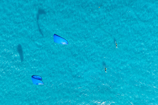 Summer holidays. Sports team. Kitesurfing on a sunny summer day. Extreme sports. Sea surface of water. Azure sea and warm weather.