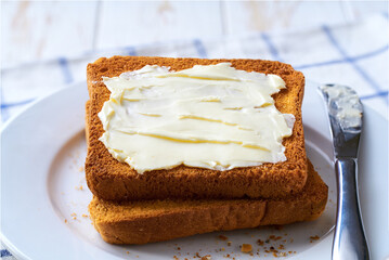 slices of toast bread slices with butter, on a white table.