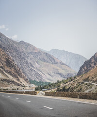 Automobile asphalt road in the mountains in the valley between rocky mountains, Pamir Highway in Tajikistan