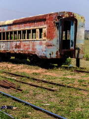 Fototapeta premium Abandoned, rusty and deteriorated second-class passenger carriage next to the Val de Palmas railway station, also abandoned, in the municipality of Bauru, state of Sao Paulo