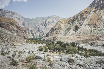The Panj River flows in the valley Along the Pamir Highway in the mountains of Tajikistan in the morning, a noisy powerful river flows among the rocks