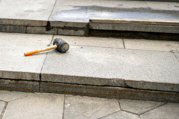 rubber mallet lies on granite tiles, a tool essential for precise stairway repair work