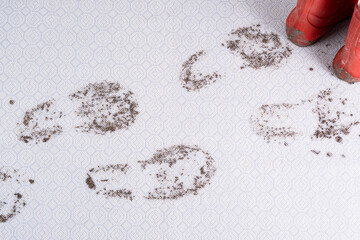 Muddy carpet. Dirty footprints in wet mud, red shoes isolated on background. dirty stains in daily...