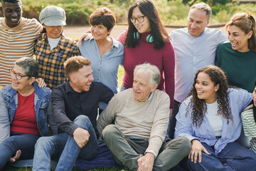 Group of multi generational people having fun together at city park - Multiracial friends outdoor -...