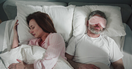 Portrait of woman feeling angry while her man snoring on bed. Adult unhappy woman can't sleep...