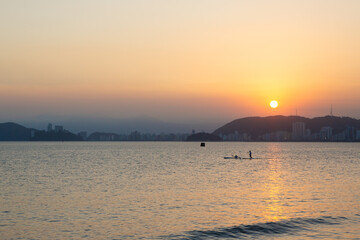 Sunset in Santos Bay with a stand up paddle paddler and another kayaker in the foreground